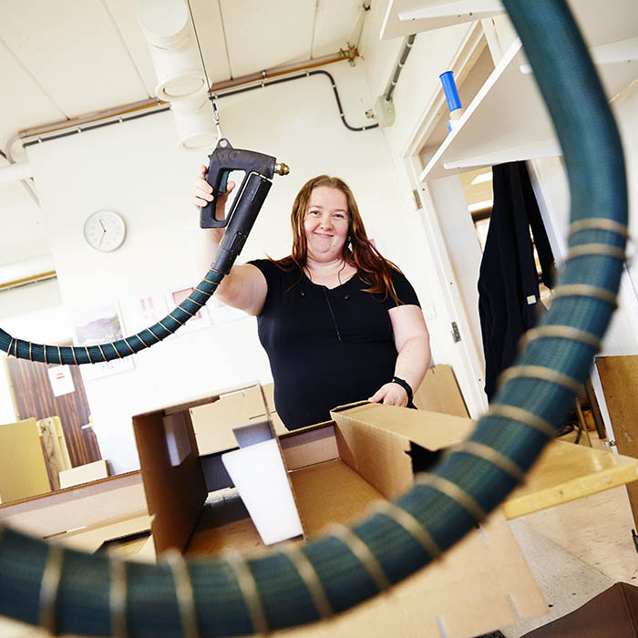 En arbeidstaker i VTA jobber med limpistol.